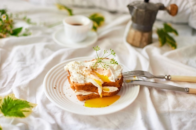 Breakfast on white bed sheets good morning toast with poached eggs coffee