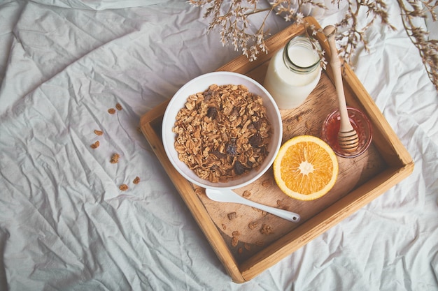 Breakfast on white bed sheets.