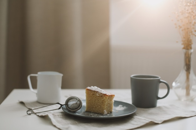 Завтрак с кусочком домашнего торта на тарелке и чашкой кофе