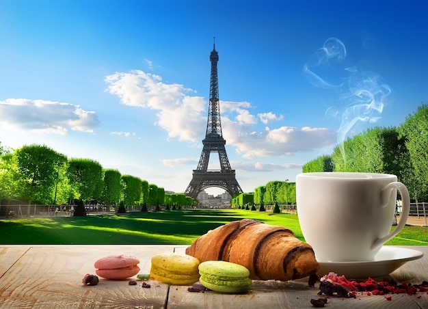 프랑스 파리의 에펠탑 근처 테이블에 빵집과 커피가 있는 아침 식사