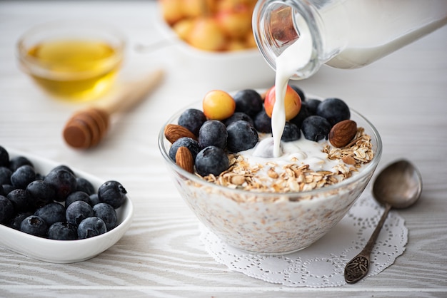 Prima colazione con latte versato farina d'avena di mirtilli e ciliegie gialle