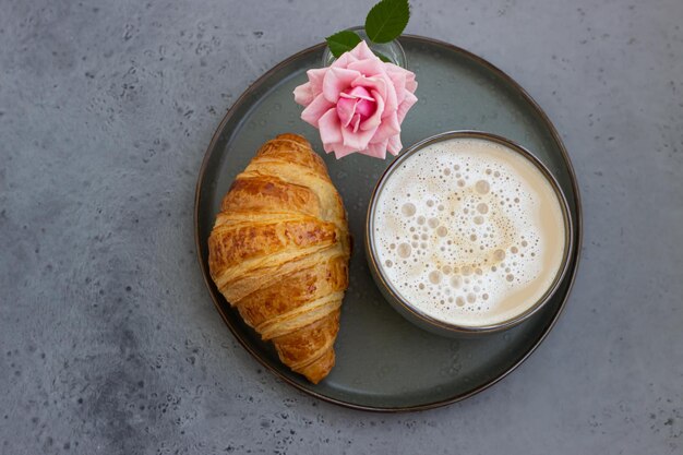 Foto colazione con croissant di caffè e rosa rosa bella composizione concetto di caffè piatto