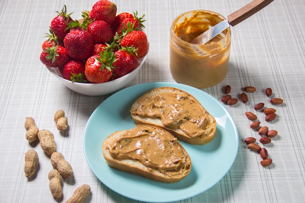 Breakfast with coffee and sandwiches with peanut paste and strawberries