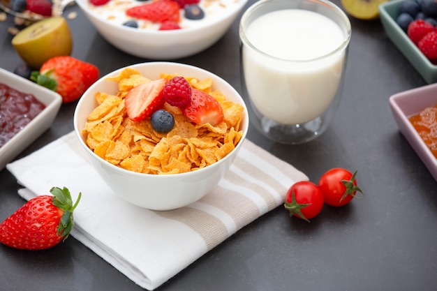 Colazione con corn flakes mescolati a cereali integrali e gruppo di frutta