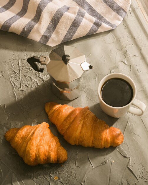 Photo breakfast with croissant and coffee and moka pot morning meal and breakfast concept top view