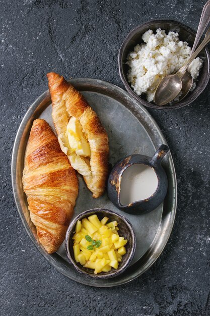 Breakfast with croissant and mango fruit