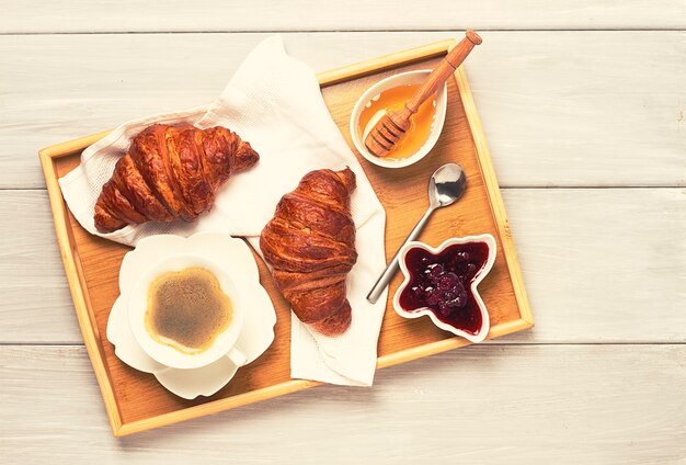 Breakfast with croissants and a cup of coffee, in bed, morning, no people,toned, . High quality photo