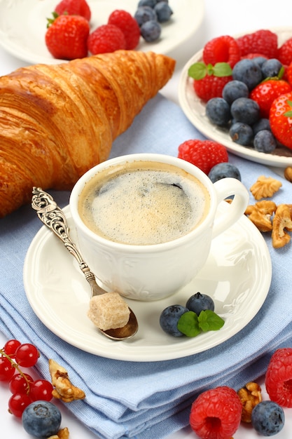 Завтрак с чашкой кофе, круассанами и ягодами