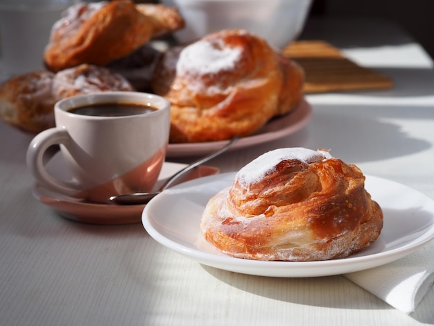 焼きたてのペストリーとブラック コーヒーの朝食