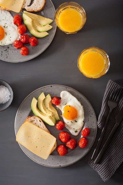 Фото Завтрак с яичницей под авокадо и помидорами с сыром