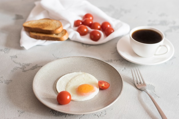 Breakfast with fried eggs, tomatoes, toast and invigorating coffee