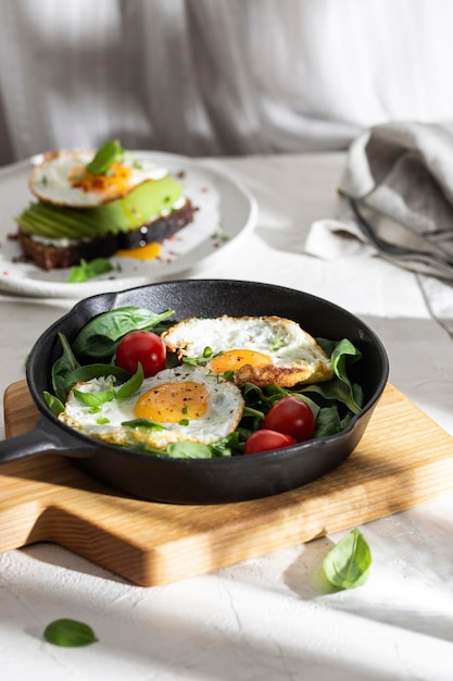 Breakfast with fried eggs and vegetables in a pan