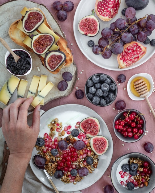 Foto colazione con frutta, formaggio, yogurt, muesli e marmellata