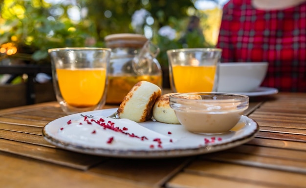 Breakfast with herbal sea buckthorn tea oatmeal porridge and cottage cheese fritters with sauce