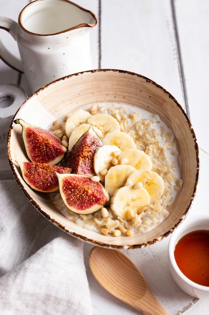 Breakfast with oatmeal porridge decorated with figs and bananas