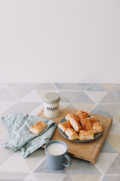 Colazione con focacce e un bicchiere di latte di pasticceria fatta in casa appena sfornata sul tavolo della cucina