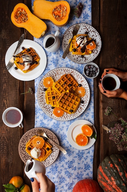 Breakfast with pumpkin waffles and ice cream, berries and chocolate