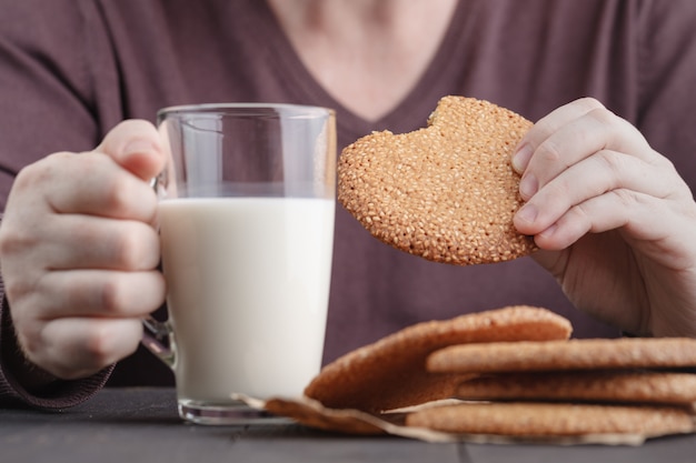 Photo breakfast with round cookie with sesame seeds and cup of milk