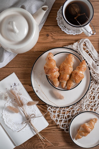 Breakfast with tea and croissants on the table