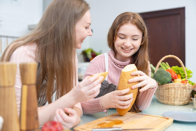 家族と一緒に朝食朝、母と娘がパンとチーズを切りました