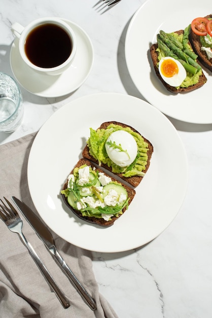 Premium Photo | Breakfast with toast avocado eggs and vegetables on a