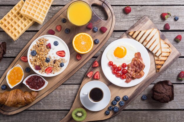 Premium Photo | Breakfast with yogurt eggs berries juice croissant and jam