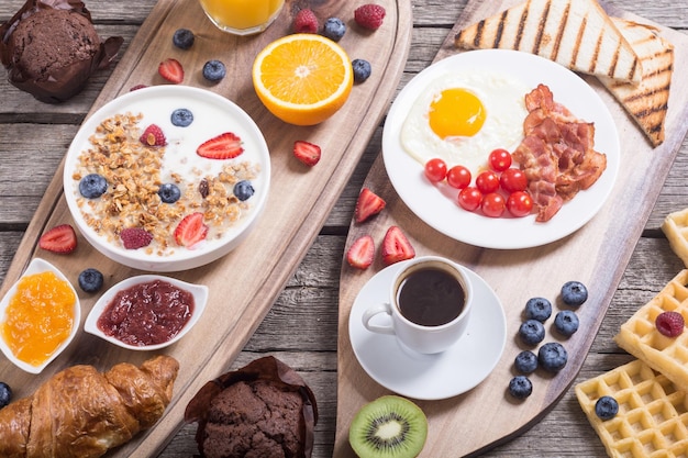 Breakfast with yogurt eggs berries juice croissant and jam