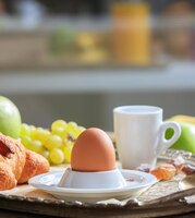 Breakfastserved fresh fruits croissants egg in eggcup and coffee on old silver tray