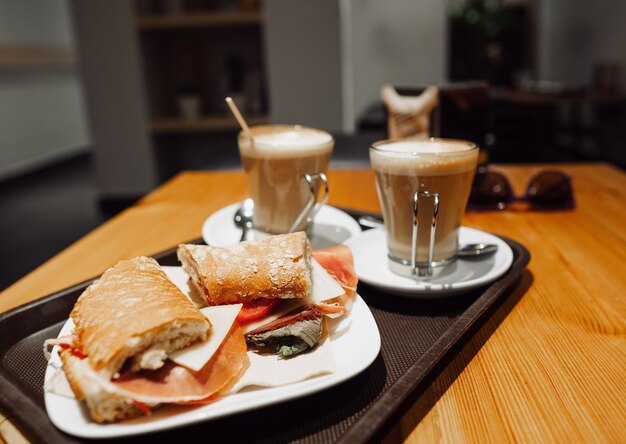 Breakfest snack - koffie latte en bocadillo sandwich op tafel in ocafe