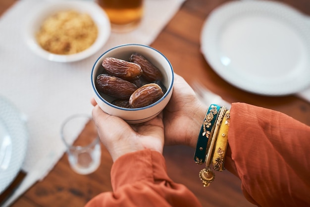 Breaking my fast the traditional way Shot of a muslim woman holding a bowl of dates to break her fast