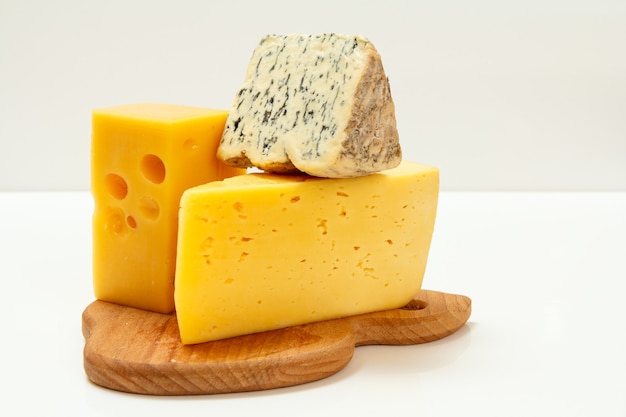 breaks of fourme d'ambert, a semi-hard french blue cheese and poland cheese hit fitness on a wooden cutting board with the white surface