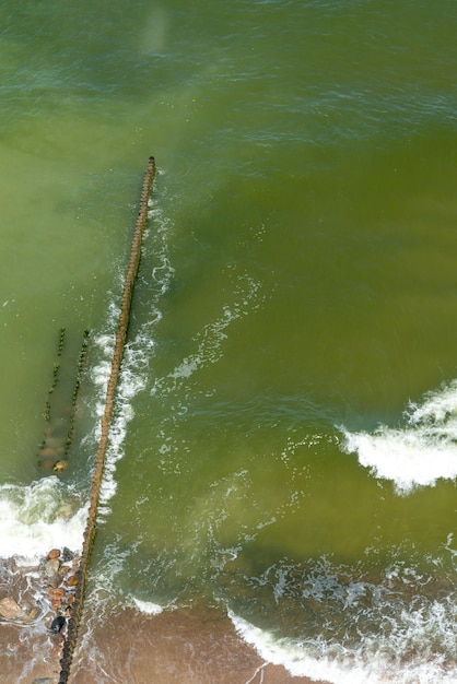 Foto un frangiflutti fatto di tronchi taglia l'onda del mare