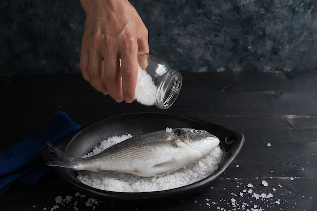 Bream in white plate on black background