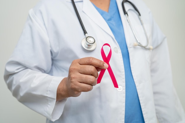 Breast cancer asian doctor woman with pink ribbon symbol of\
world breast cancer day