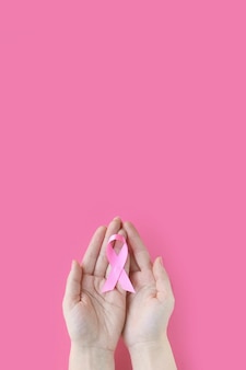 Concetto di consapevolezza del cancro al seno io sono e lo farò mani di donna che tengono un nastro rosa