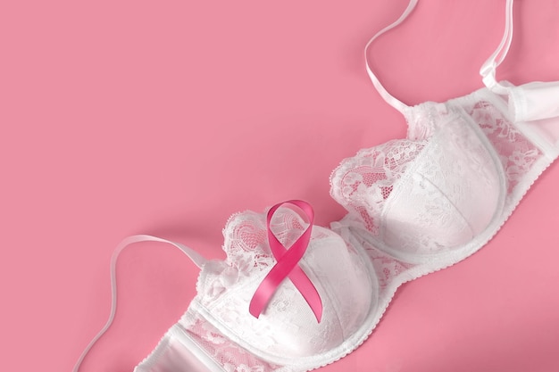 乳がんの意識とヘルスケアと医学のコンセプト白いレースのブラにピンクのリボンコピースペース