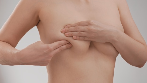 Breast cancer awareness. Young woman doing breast self-exam (BSE)