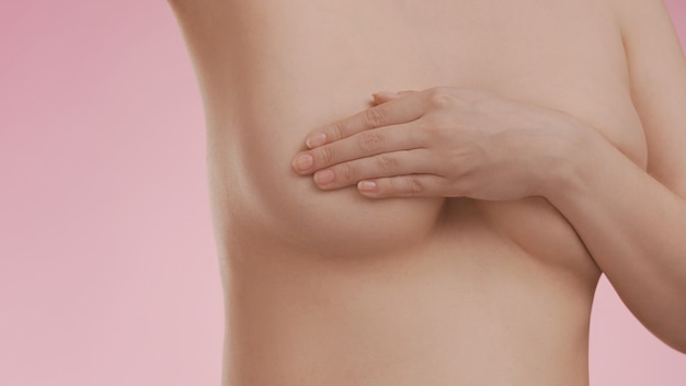 Breast cancer awareness. Young woman doing breast self-exam (BSE)