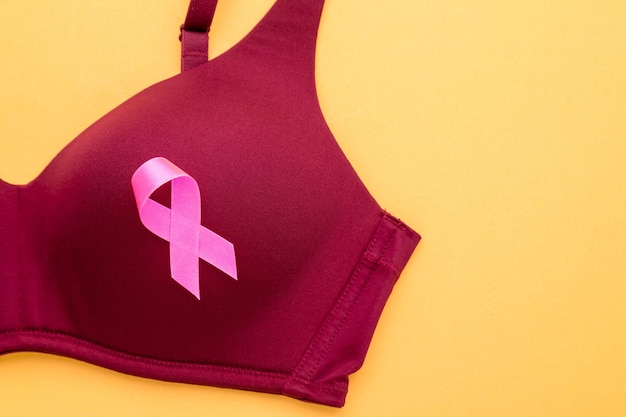 Foto concetto di cancro al seno: nastro rosa e reggiseno da donna simbolo della campagna contro il cancro al seno