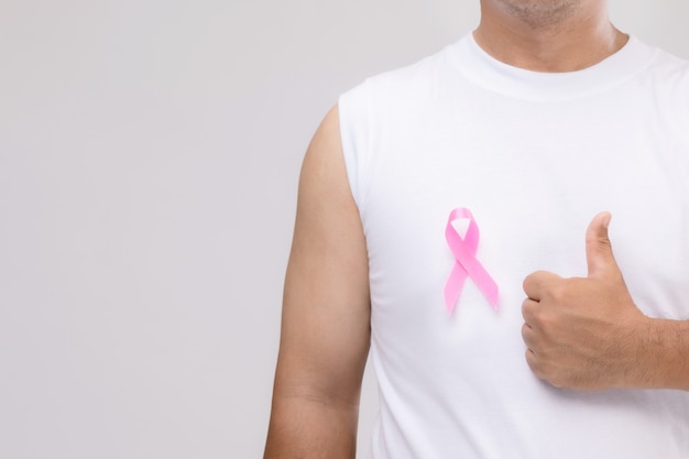 Breast cancer in men concept : Portrait Asian man and pink ribbon the symbol of breast cancer campaign. 