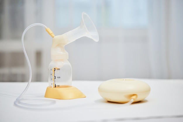 Breast pump with empty baby bottle on table