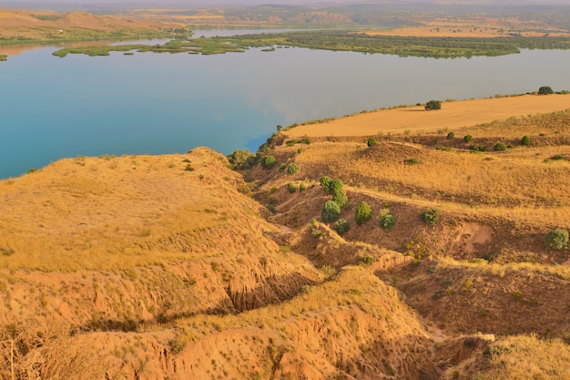 Breathtaking landscape of mountains surrounding a calm lake in the Barrancas de Burujon, Toledo, Spain