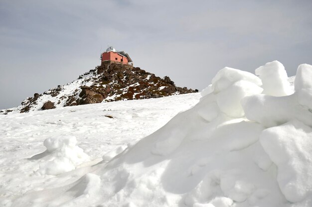 シエラネバダ山脈の息をのむような雪に覆われた冬の風景と、遠くの展望台が氷のように冷たい空を背景に見えます