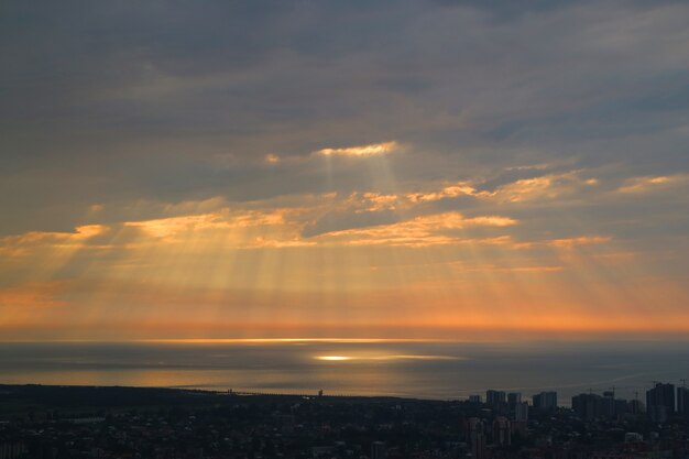 Breathtaking Sunrise Sky with the Angel Ladder over the Sea and the City