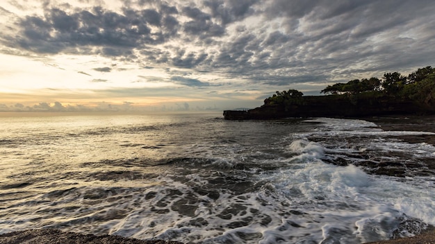 Photo breathtaking sunset in bali near tanah lot temple, indonesia