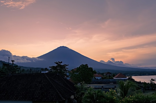 バリ島、インドネシアのアメッド ビーチからアグン火山の息をのむような夕日の景色