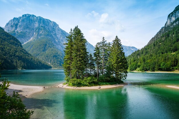 Breathtaking view of lush trees and emeraldgreen waters in Lago del Predil near Tarvisio in Italy