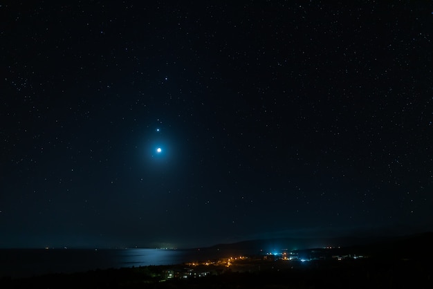 夜明け前の星空の息を呑むような景色金星木星と月が並ぶ