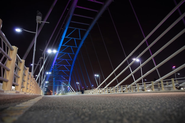 Brede nacht asfaltweg op de achtergrond van de brug