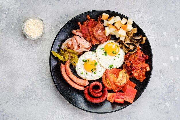 Brekfast plate. Fried egg, sausage, champignon, bacon, bean ragout, ham, cheddar, tomato and bell pepper